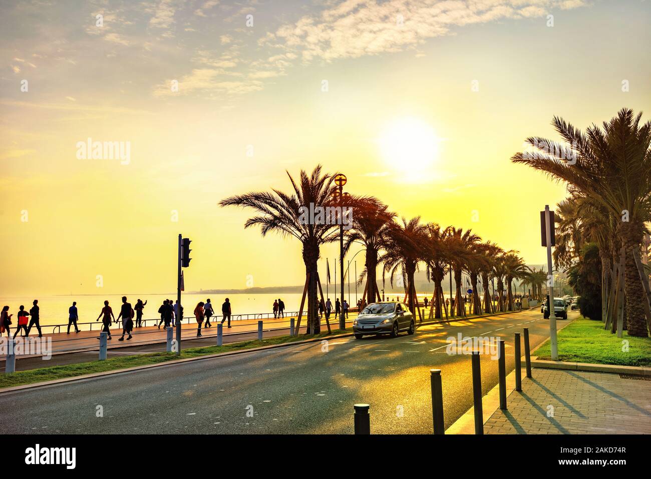 Küstenstraße entlang der Promenade des Anglais. Touristen zu Fuß und Ruhen, Sonnenuntergang in Nizza. Frankreich, Cote d'Azur Stockfoto