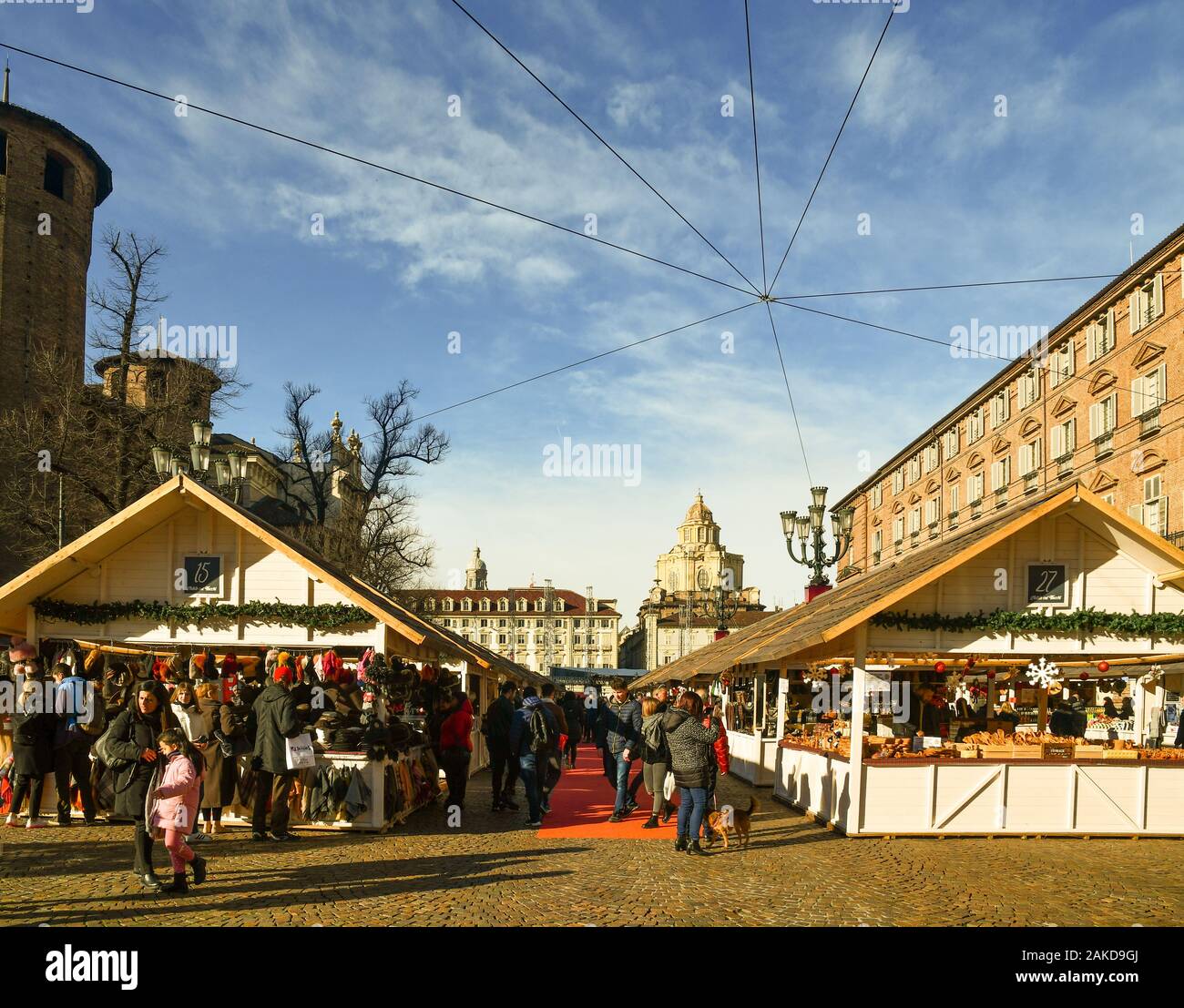 Der Weihnachtsmarkt auf der Piazza Castello Platz im Zentrum von Turin mit einem Straßenmusiker und Leute einkaufen am Heiligabend, Piemont, Turin Stockfoto