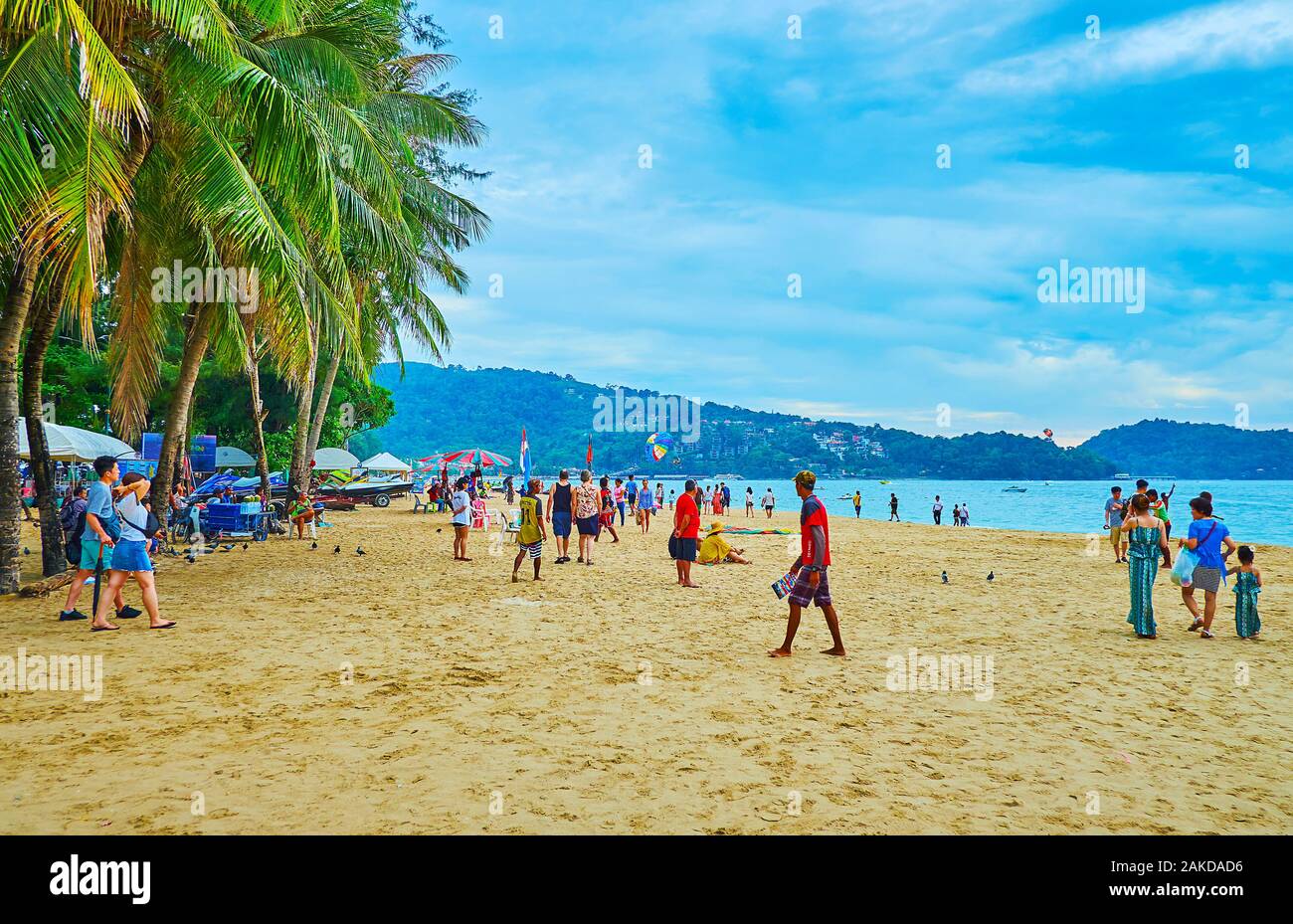 PATONG BEACH, THAILAND - Mai 1, 2019: Die komfortablen Sand Beach Resort mit schattenspendenden Palmen und hügelige Küste, am 1. Mai in Patong Stockfoto