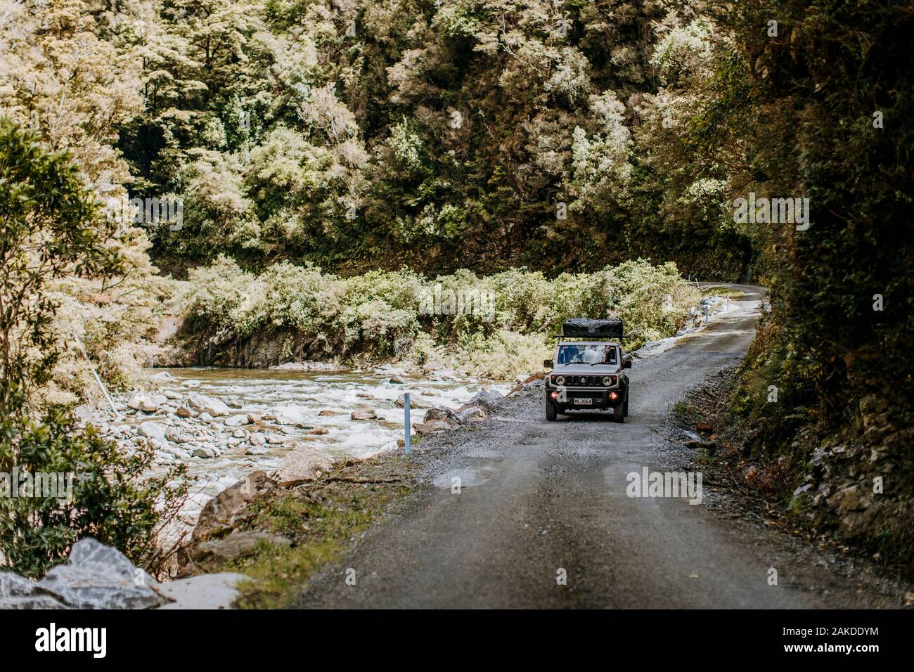 SUV fährt in Neuseeland raue Straße in der Schlucht neben dem Fluss Stockfoto