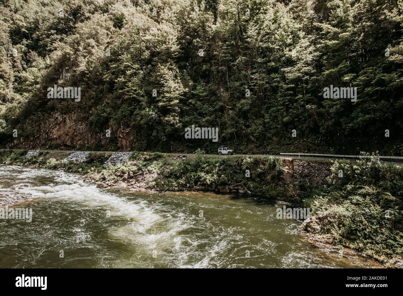 SUV fährt auf einer rauen Straße neben dem Fluss in Gorge, Neuseeland Stockfoto