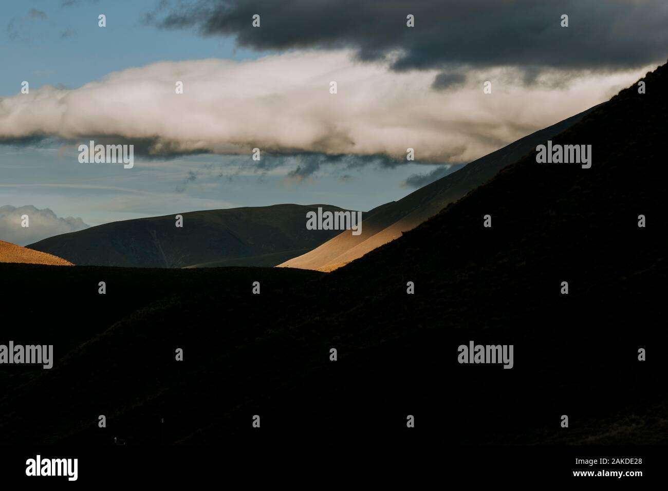 Dramatisches Sonnenlicht trifft einen entfernten Berghang nahe Lindis Pass, NZ Stockfoto