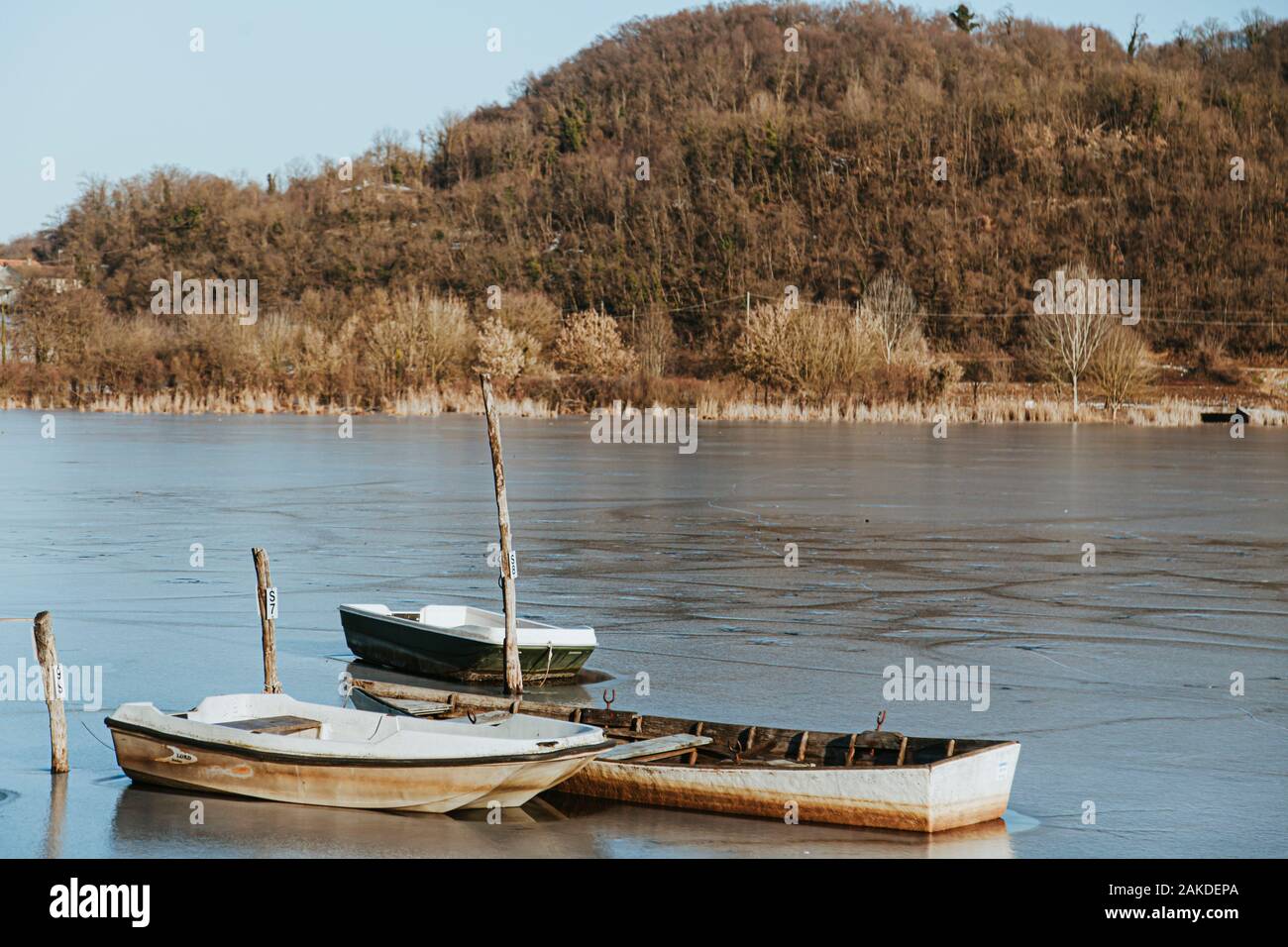 Eisige ländliche Landschaft, drei Boote auf einem gefrorenen See Stockfoto
