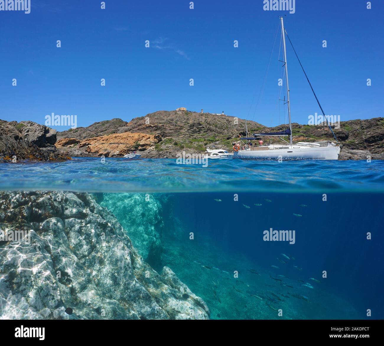 Mittelmeer im Sommer, felsige Küste mit Boote und einige Fische unter Wasser, geteilte Ansicht über und unter Wasser Oberfläche, Spanien, Costa Brava, Katalonien Stockfoto