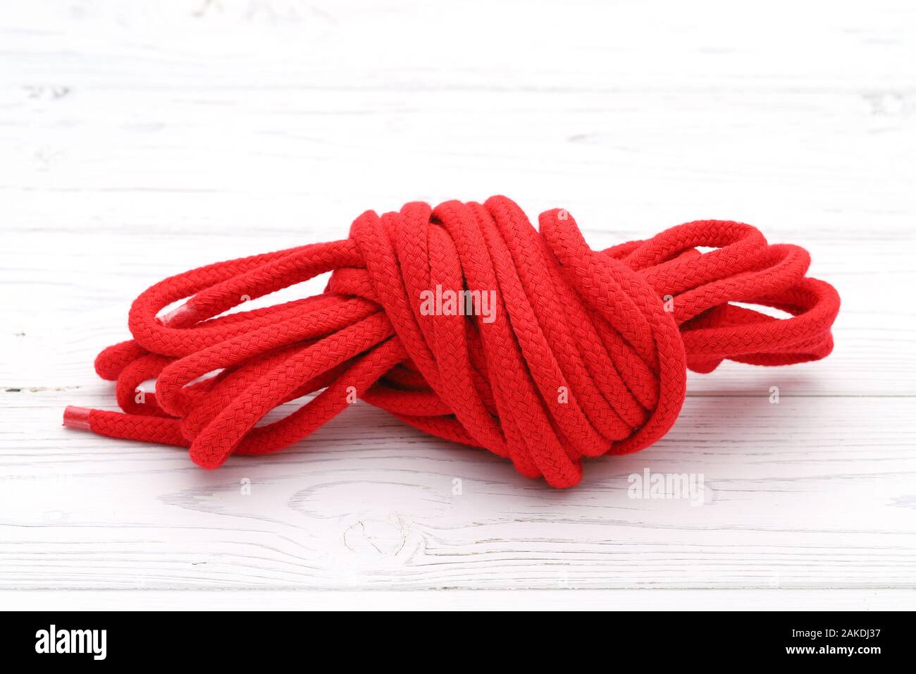 Bündel von rot Baumwoll Seil auf weissem Holztisch Bündel von rot Baumwoll Seil auf weissem Holztisch Stockfoto