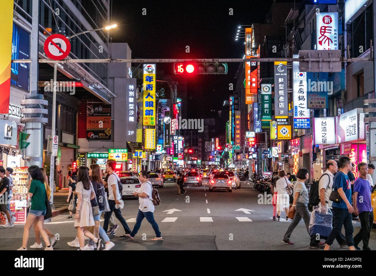 Fußgänger gehen nachts über einen Fußgängerüberweg im Zentrum von Taipei City, Taiwan Stockfoto