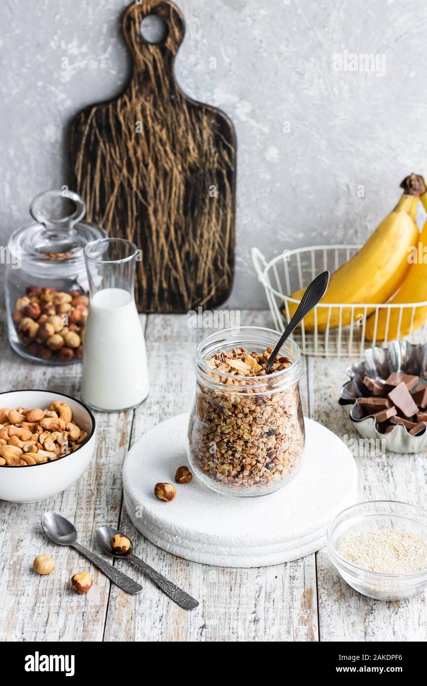 Schokolade Banane Müsli mit Nüssen in einem Glas auf einem hellen Hintergrund. Ein schnelles Frühstück Option Stockfoto