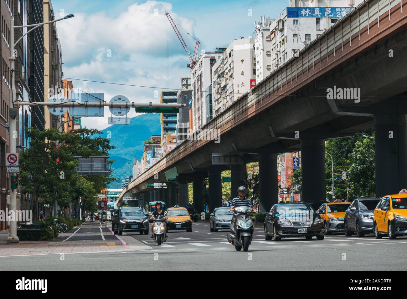 Der Verkehr fährt parallel zu einem erhöhten Streckenabschnitt auf der Metro Taipeh nahe dem Bahnhof Daan Stockfoto