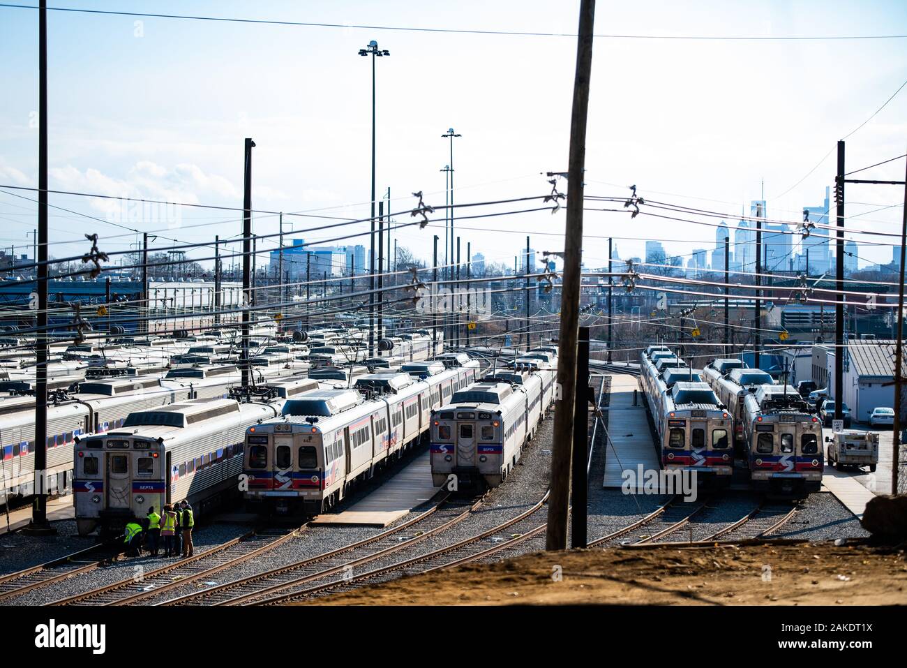 Bild von SEPTEN transit Arbeiter, die auf Schienen an der Vorderseite eines Zuges mit dem Philadelphia Skyline im Hintergrund gesammelt. Stockfoto