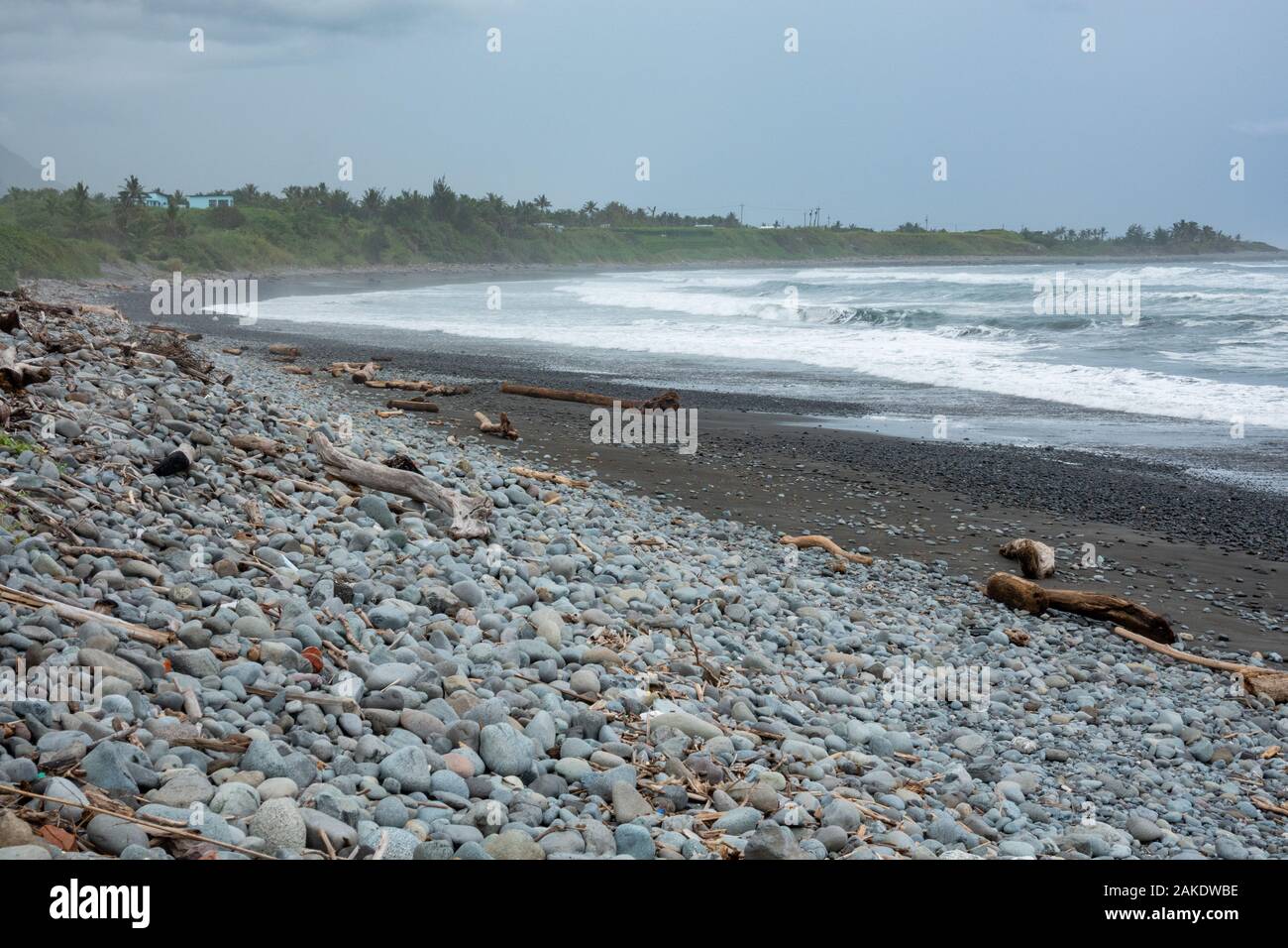 Starke Wellen brechen auf der felsigen Ufer des Dulan Beach, im südlichen Taiwan, nach einem Zyklon vorbei, große Stücke Treibholz Stockfoto