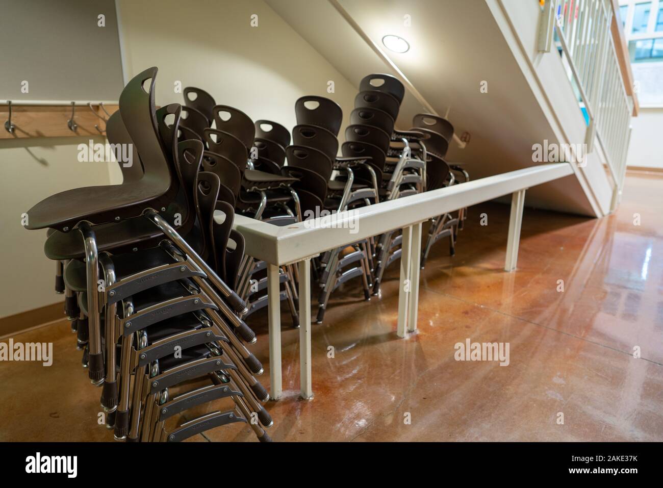 Braun stapelbare Stühle an einer Schule Einstellung unter Treppe gestapelt Stockfoto