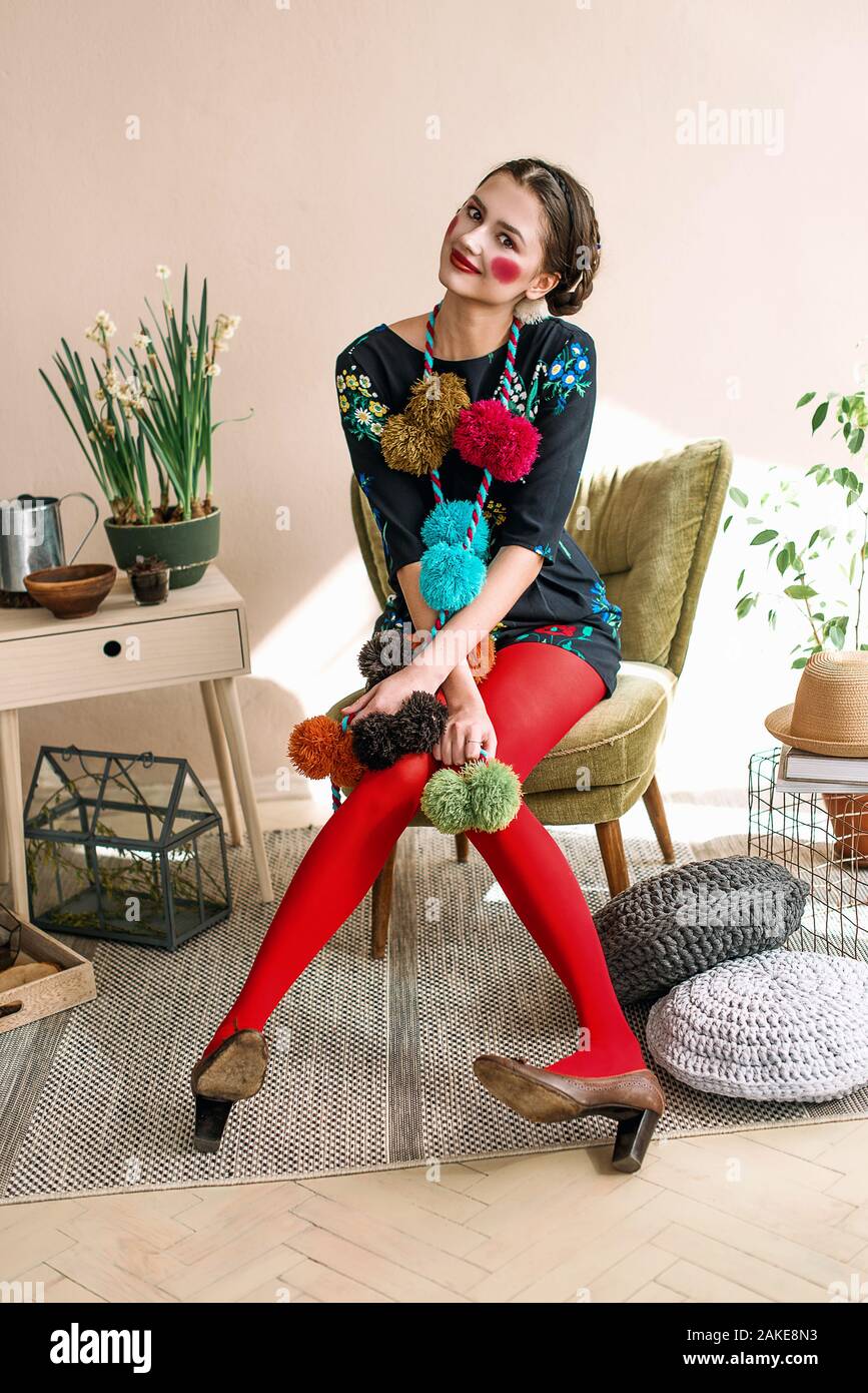 Modische schöne Brünette glückliches Mädchen in einem jumpsuit mit floraler Stickerei mit Farbe Make-up: rote Wangen und Lippen. Granny chic Stil. Retuschiert po Stockfoto
