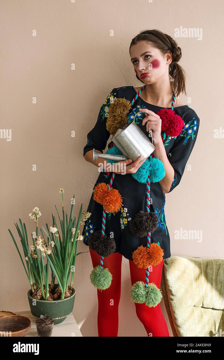 Modische schöne Brünette glückliches Mädchen in einem jumpsuit mit floraler Stickerei mit Farbe Make-up: rote Wangen und Lippen. Granny chic Stil. Retuschiert po Stockfoto