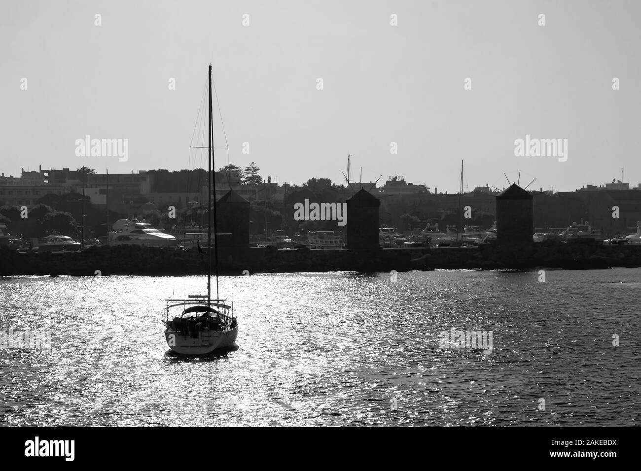 Schwarze und weiße Silhouette einer Yacht in den Hafen von Rhodos bei Sonnenuntergang. Dodekanes Griechenland Stockfoto