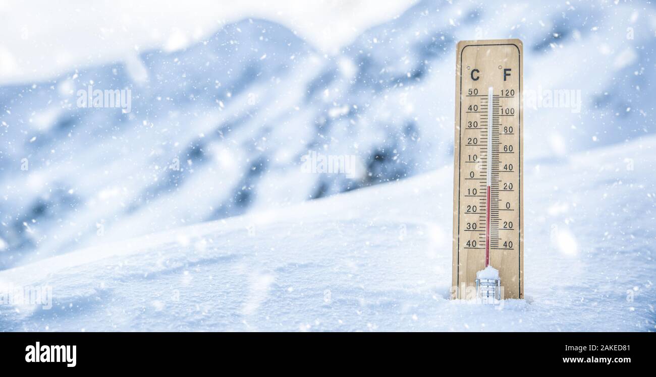 Thermometer auf den Bergen im Schnee zeigt Temperaturen unter Null. Niedrige Temperaturen in Grad Celsius und Grad Fahrenheit bei Schneewetter Stockfoto