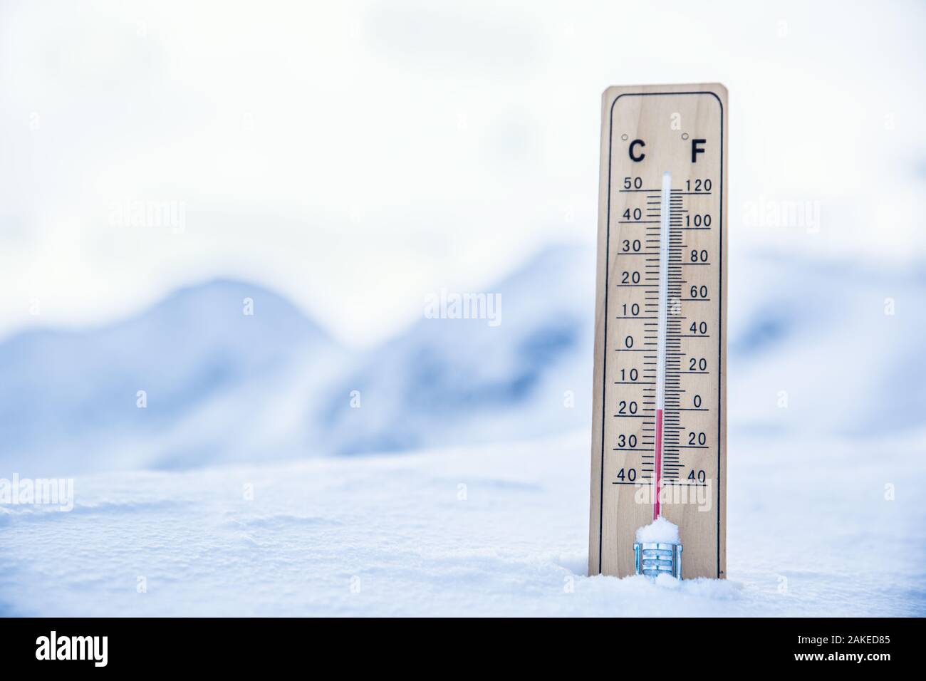 Thermometer auf den Bergen im Schnee zeigt Temperaturen unter Null. Niedrige Temperaturen in Grad Celsius und Grad Fahrenheit Stockfoto