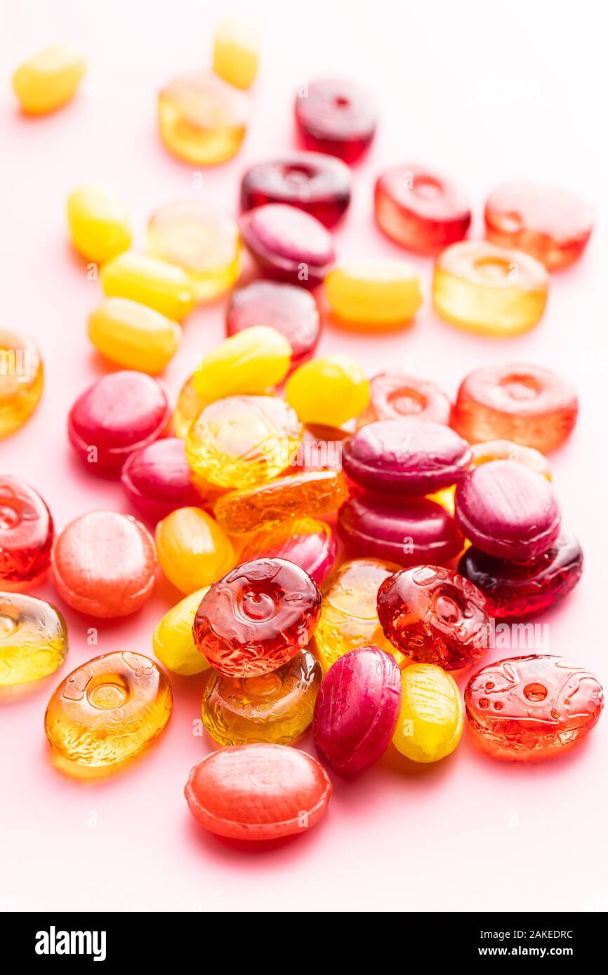 Süße bunte Bonbons auf rosa Hintergrund. Stockfoto