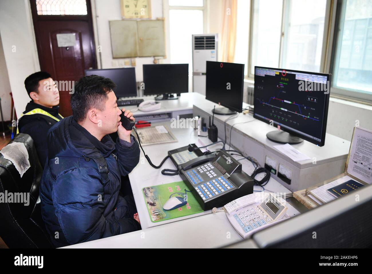 (200109) - BAOJI, Januar 9, 2020 (Xinhua) -- ren Pengtao (vorne), der Offizier im Dienst, ist in die gemeinsame Kontrolle mit der Bahn in Betrieb bei Qingshiya Bahnhof in Baoji Stadt, in der Provinz Shaanxi im Nordwesten Chinas, dem 7. Januar 2020. Qingshiya Bahnhof ist an der Spitze der Qinling Mountains auf Chinas erste elektrifizierte Eisenbahn, Baoji - Chengdu Eisenbahn. Von steilen Klippen umgeben, die 'Cloud' besteht aus nur zwei Titel und dient als einen kurzen Stop für die vorbeifahrenden Züge auf der Bahn. Klein, wie er ist, die Station hat alle die lebenswichtigen Organe. Für den Betrieb des Bahnhofs garantieren, Stat Stockfoto