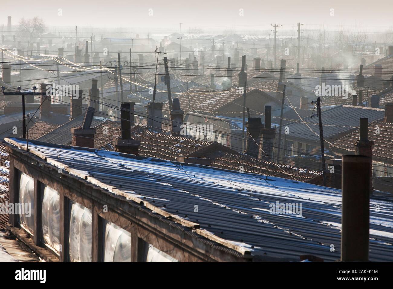 Wohnungen in Suihua mit Rauch aus den Schornsteinen, Provinz Heilongjiang, China. Stockfoto