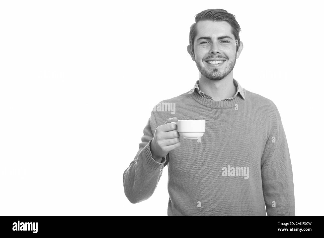Junger glücklicher kaukasischer Mann mit Kaffeetasse Stockfoto