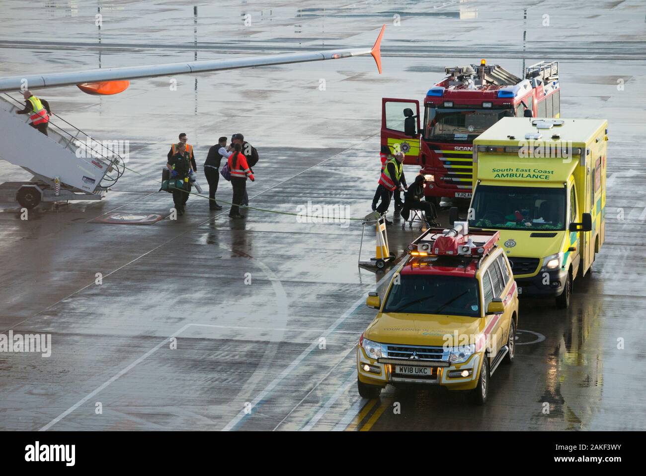 Rettungskräfte, Sanitäter, Rettungswagen Sanitäter nehmen an einem Flugzeug/Flugzeug/Flugzeug, nachdem ein Passagier während eines Rückflugs zum Flughafen krank geworden ist/krank geworden ist. England Großbritannien (115) Stockfoto