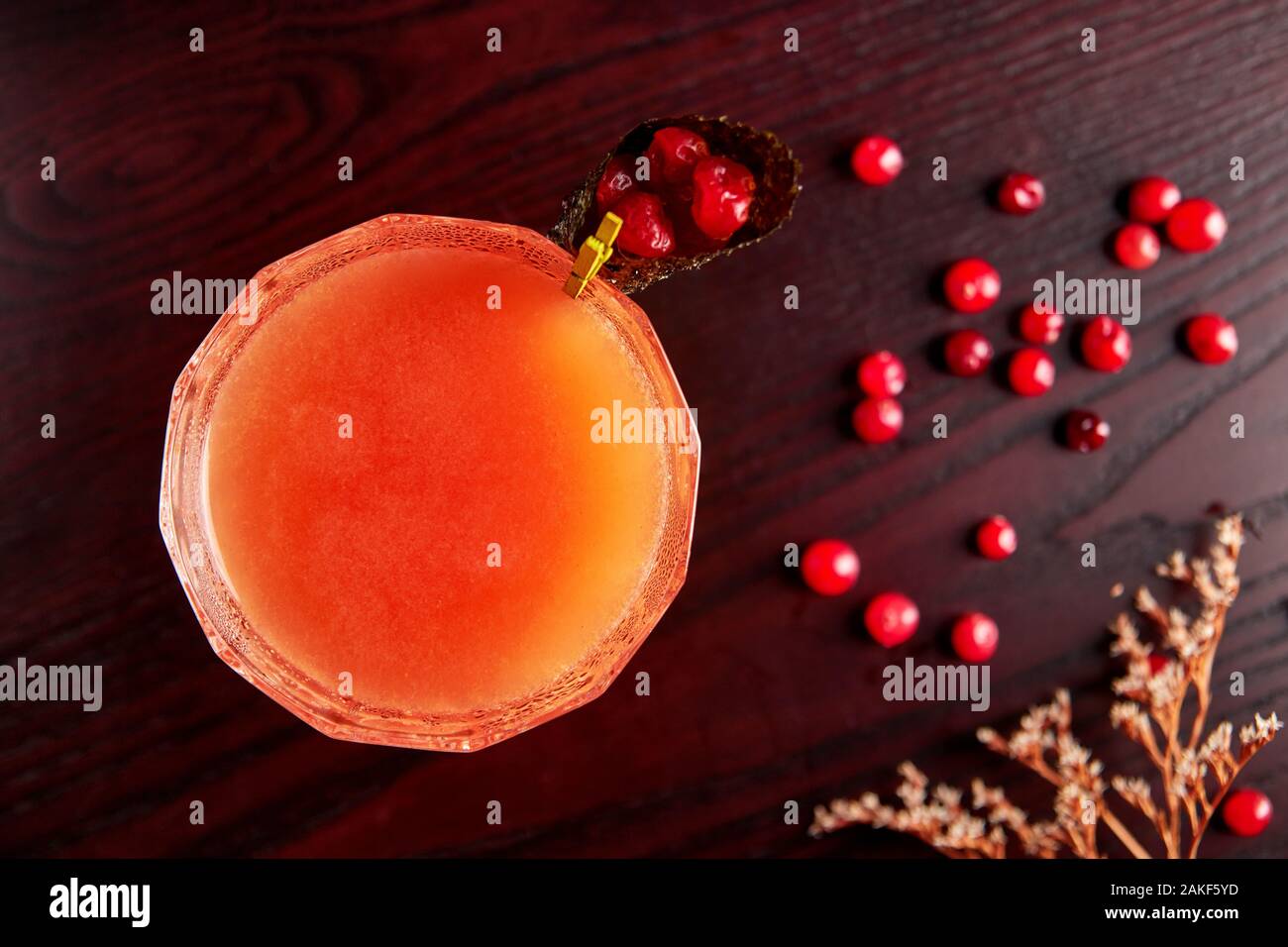 Red Cocktail in Coupé Glas mit Cranberry Saft aus frischen Preiselbeeren in Nori Kegel eingerichtet, Cosmopolitan auf hölzernen Tisch Stockfoto