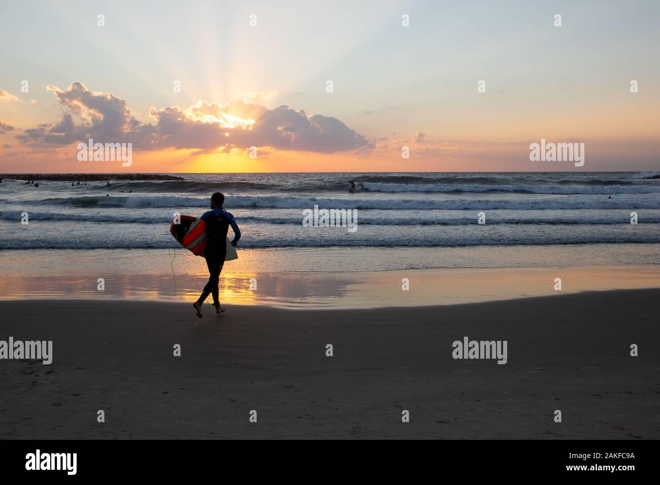 Silhouette von Surfer am Strand des Mittelmeers. In Tel Aviv bei Sonnenuntergang fotografiert. Stockfoto