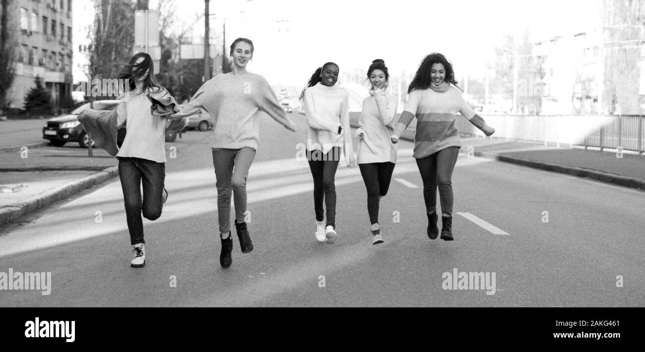 Multiethnische Gruppe von Freunden aus fünf junge Frauen läuft und ein Spaß auf der Straße der Stadt. Das Konzept von Freundschaft und Einheit zwischen verschiedenen menschlichen Rasse Stockfoto