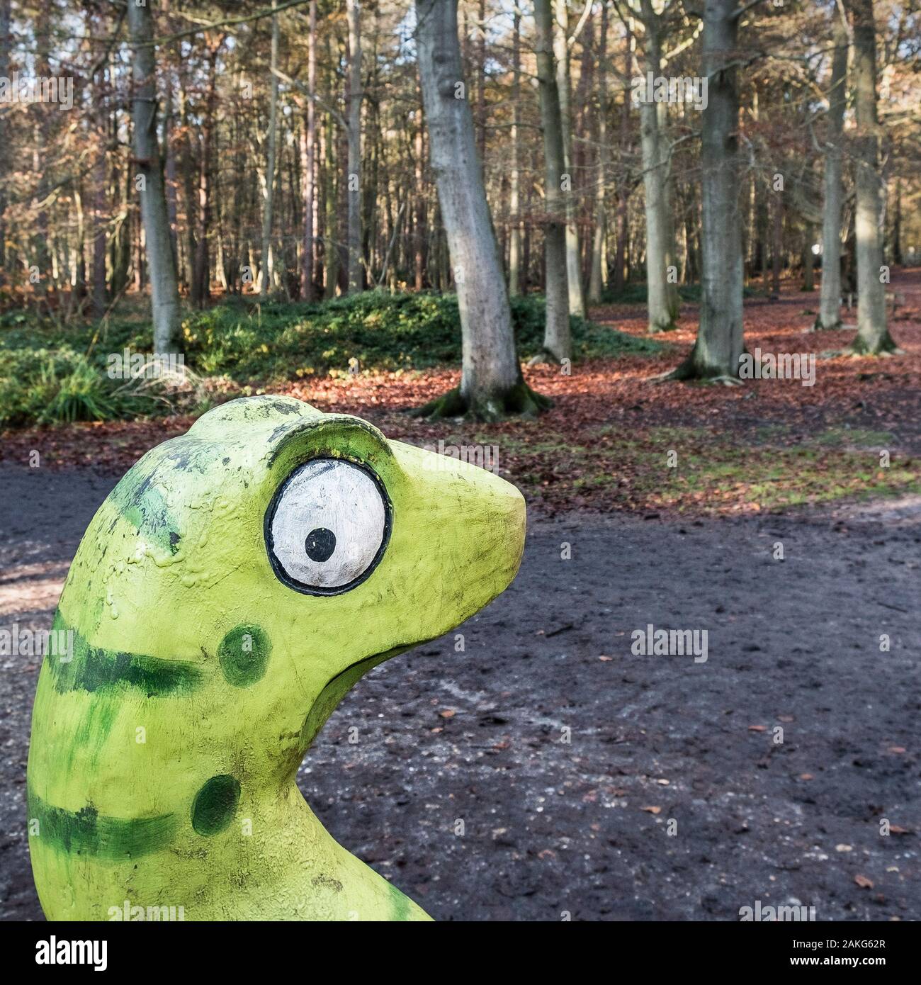 Eine aus Holz geschnitzte grüne Schlange in eine herbstliche Thorndon Park North in Brentwood, Essex, an. Stockfoto