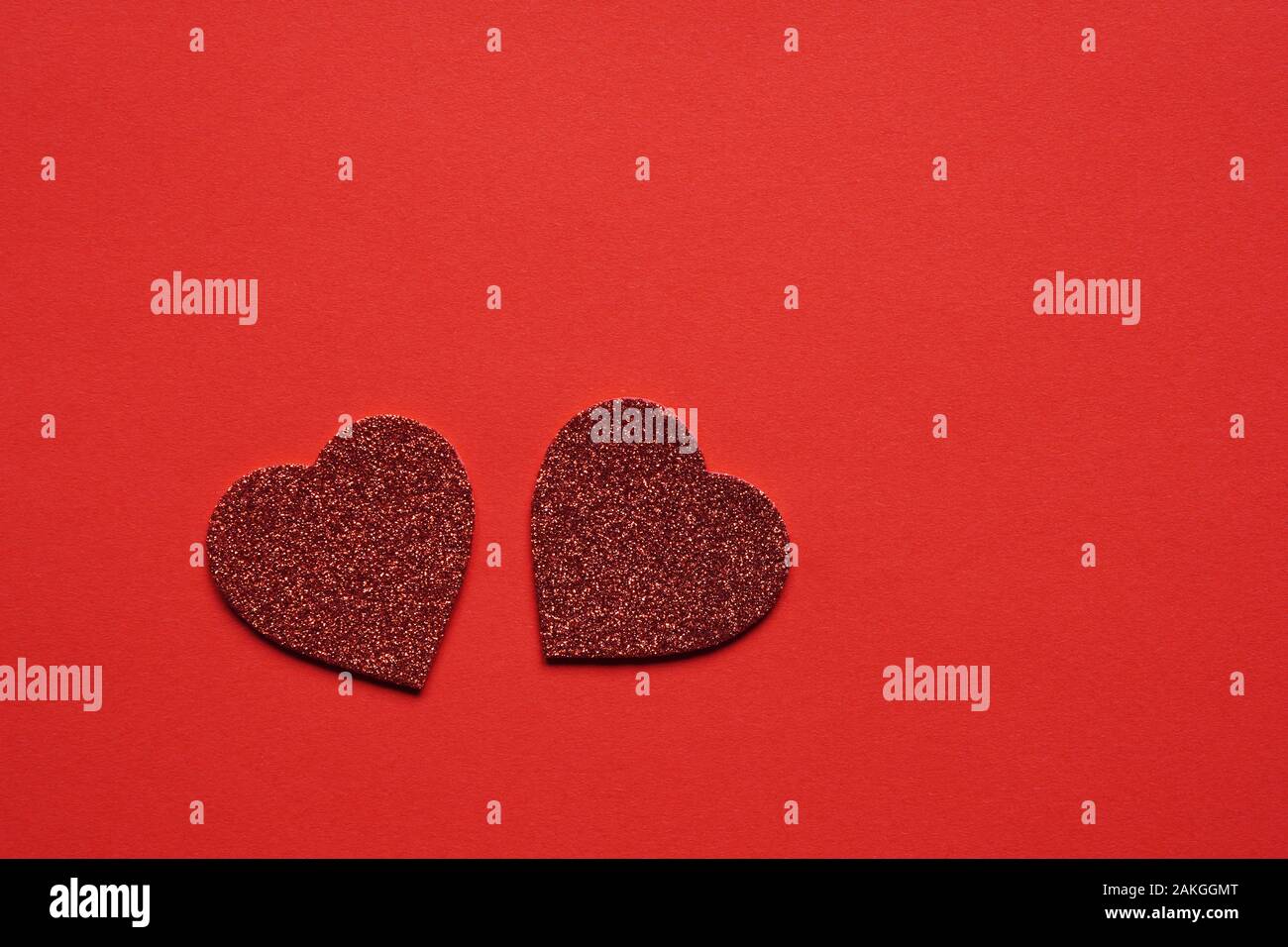 Zwei herzförmigen Glitzer Herzen auf rotem Hintergrund mit Kopie Raum - Valentinstag Hochzeit oder Jubiläum Konzept Stockfoto