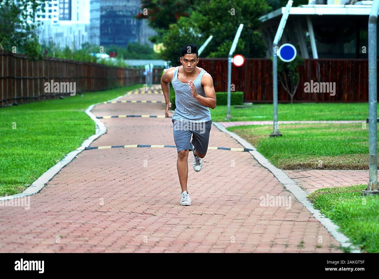 Junge asiatische Männer laufen vor die Kamera - Begeisterung junge Sport am Nachmittag auf dem Campus Stockfoto