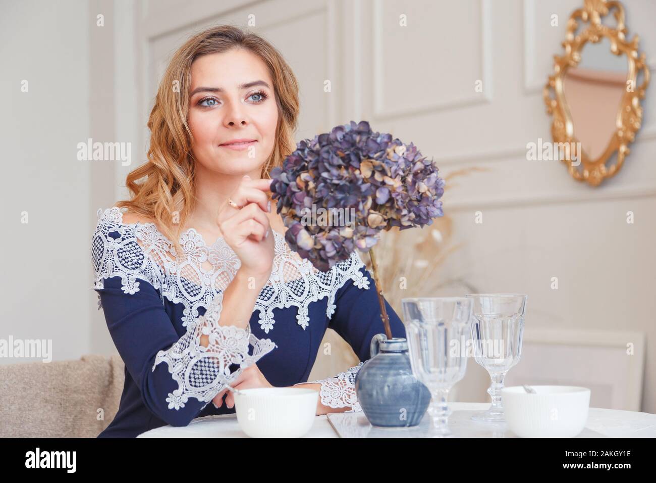 Allein Denken junge Frau mit langen, lockigen Haar sitzt im Cafe. Stockfoto