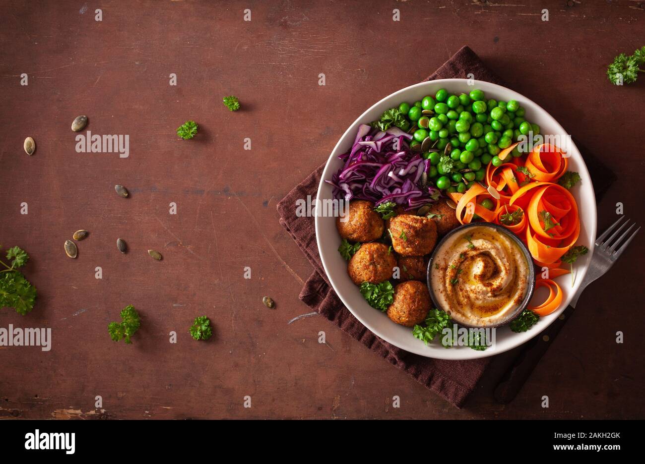 Gesund vegan Mittagessen Schüssel mit falafel hummus Karotte Bänder Kohl und Erbsen Stockfoto