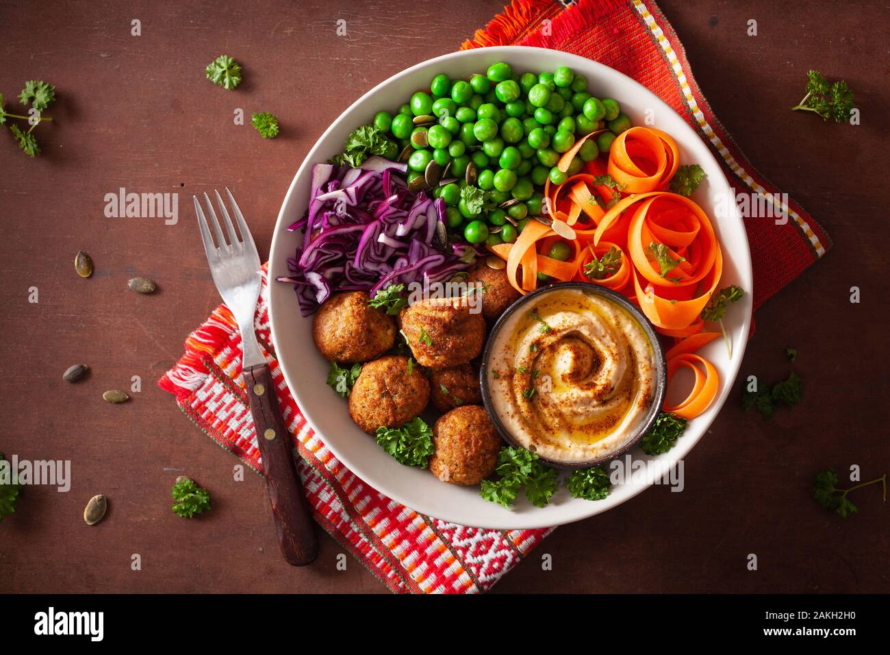 Gesund vegan Mittagessen Schüssel mit falafel hummus Karotte Bänder Kohl und Erbsen Stockfoto