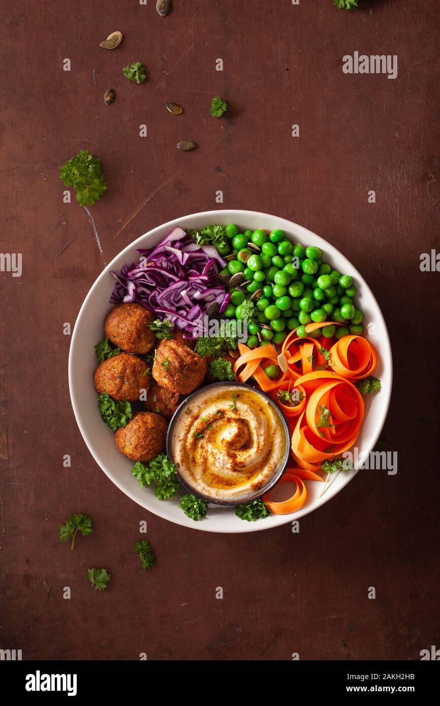 Gesund vegan Mittagessen Schüssel mit falafel hummus Karotte Bänder Kohl und Erbsen Stockfoto
