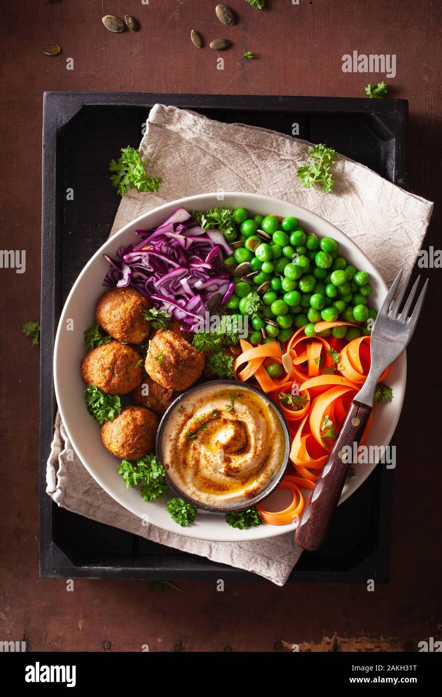 Gesund vegan Mittagessen Schüssel mit falafel hummus Karotte Bänder Kohl und Erbsen Stockfoto