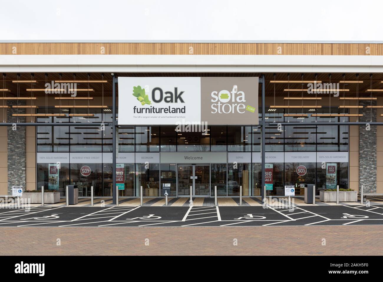 Rugby, Warwickshire, Großbritannien: Oak Furnitureland und Sofa Store Outlet hinter einigen Behinderten-Parkplätzen im Elliott's Field Retail Park. Stockfoto
