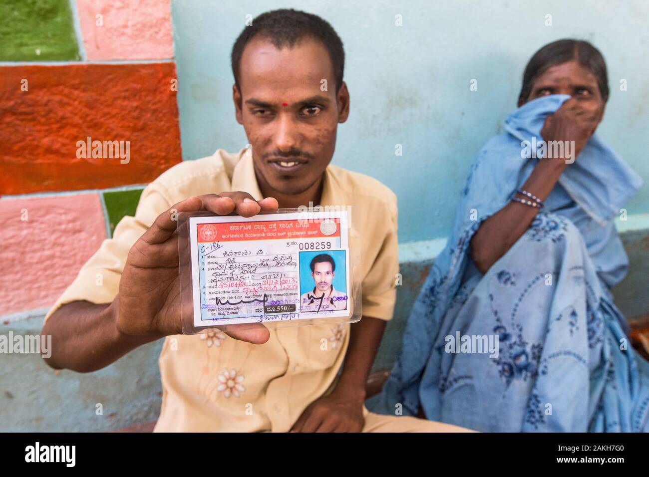 Bildunterschrift: Sehbehinderte Selbsthilfegruppe (SHG) Mitglied Shivaraju stolz zeigt den Bus Pass, dass seine Mitgliedschaft in der Gruppe ihm geholfen hat zu Sek Stockfoto