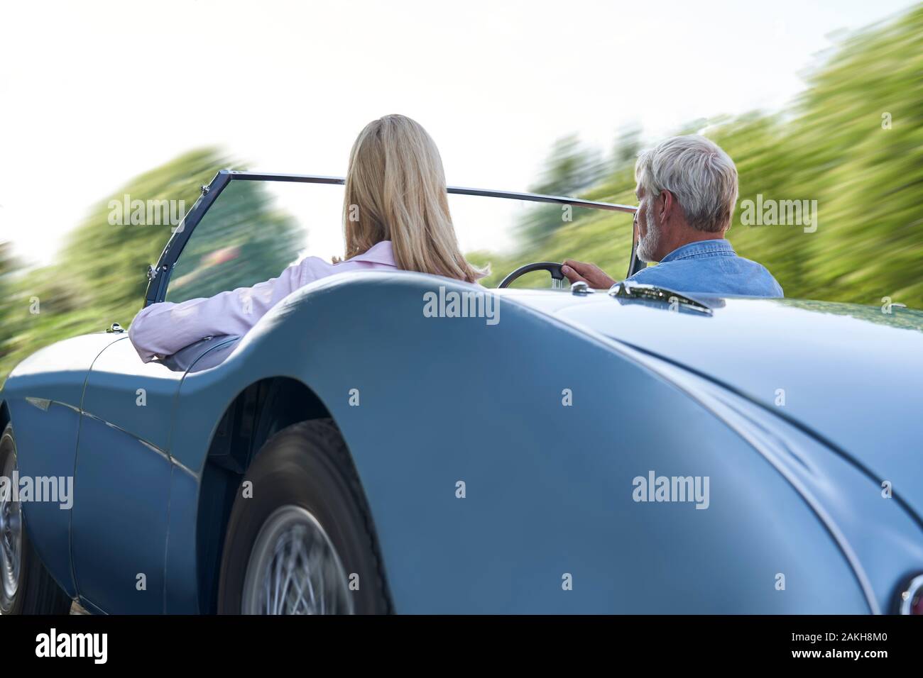 Ansicht der Rückseite des Reifes Paar Genießen Reise In der Klassischen offenen Sportwagen zusammen Stockfoto