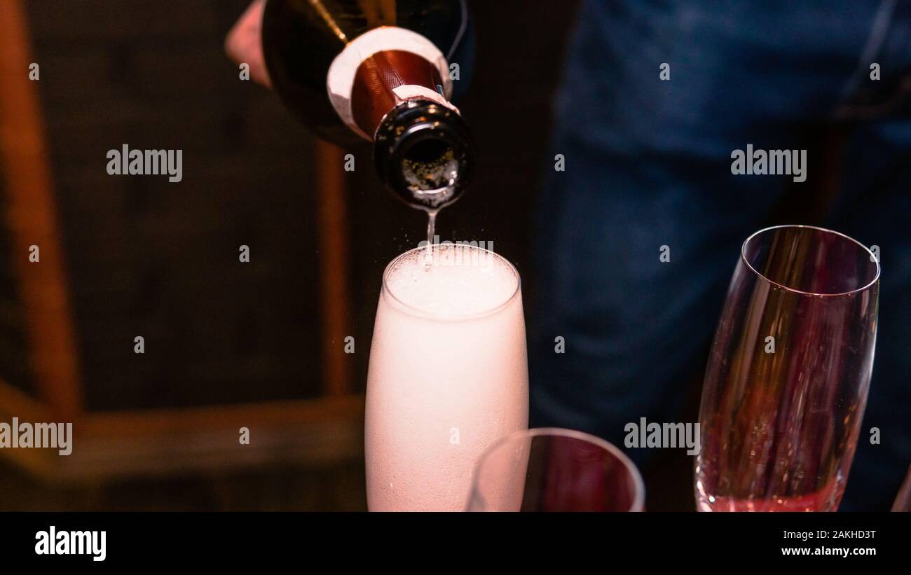 Close-up of Champagne in ein Glas Wein einzuschenken. Konzept aus Restaurant, Bar und Catering Service Stockfoto