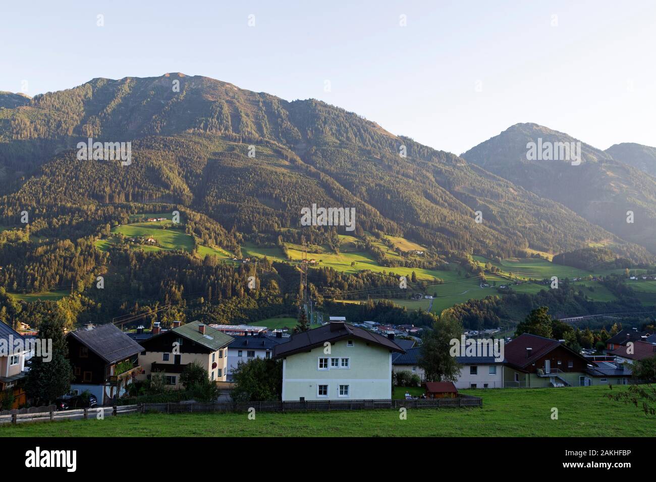 Häuser in das Salzachtal in St. Veit im Pongau, Österreich. Tannen wachsen auf den Berghang oberhalb der Gebäude. Stockfoto