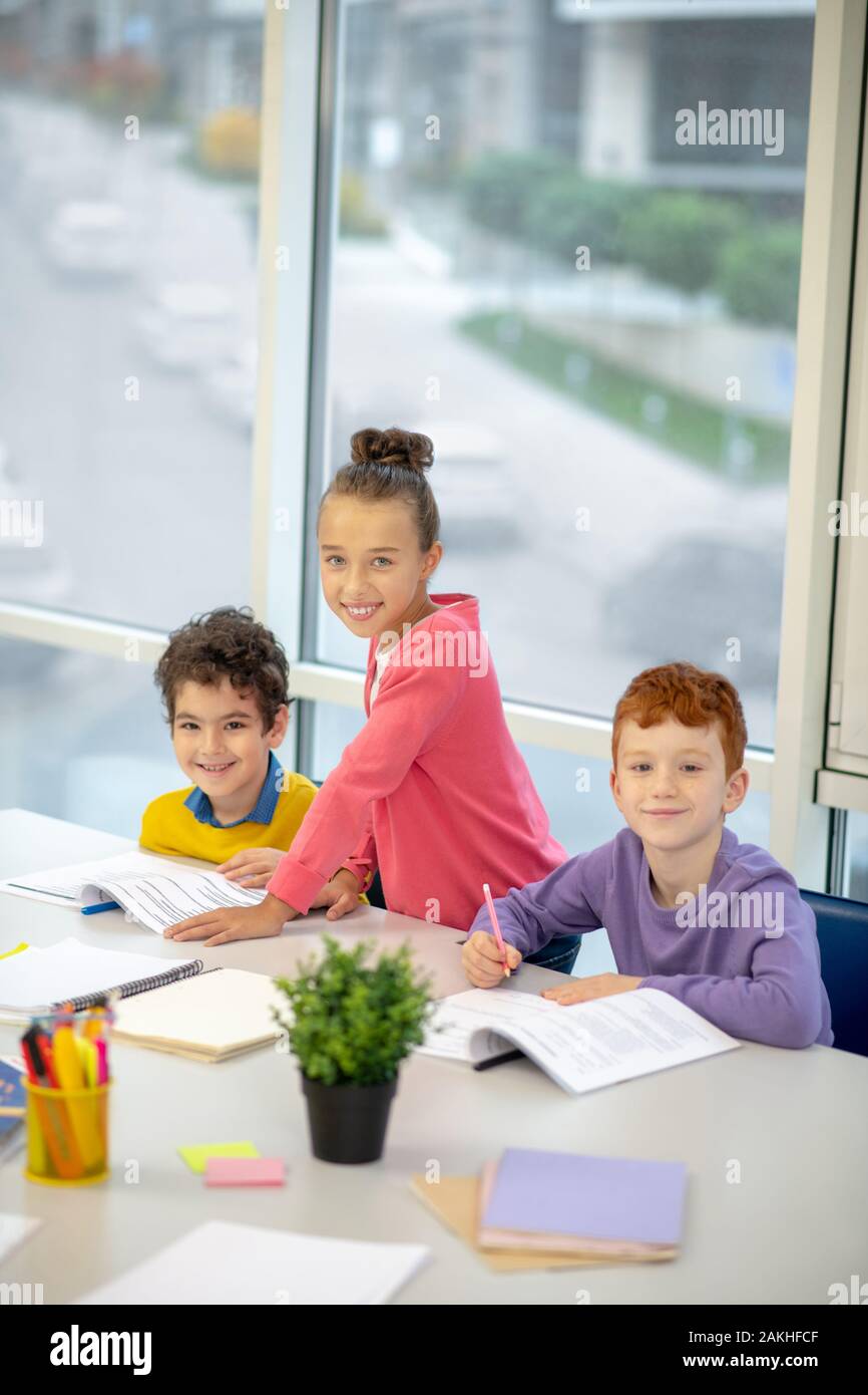 Drei glückliche Kinder Gruppe Aufgabe zusammen Stockfoto