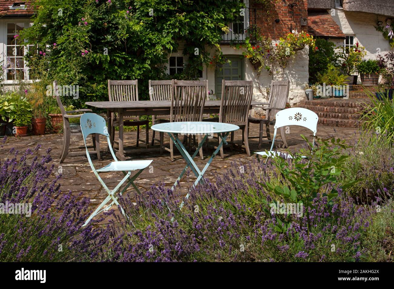 Sitzmöbel im Metallgarten auf der Steinterrasse im englischen Sommergarten Stockfoto