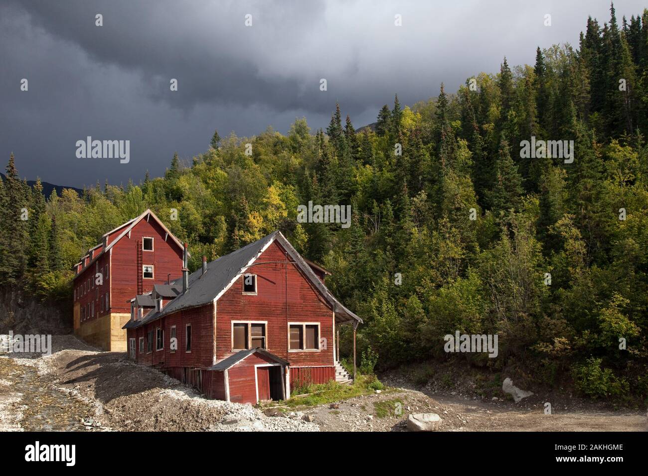 Zwei rote Holz- Cooper Mühle Gebäude umgeben von Nadelwald, Wrangell-St. Elias National Park, Kennecott, Alaska, USA Stockfoto