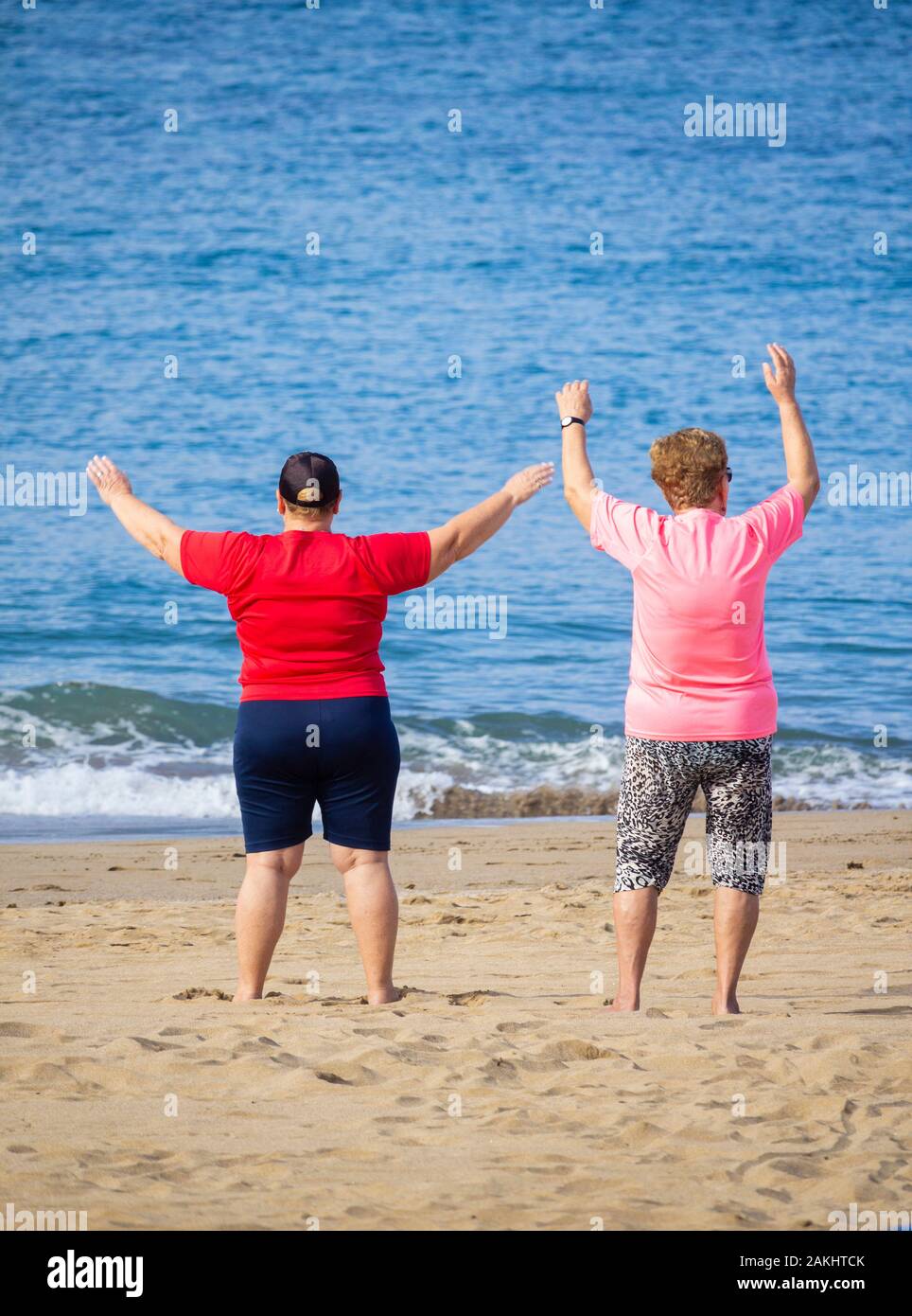 Ansicht der Rückseite des Älteren beleibte Frau trainieren am Strand. Stockfoto