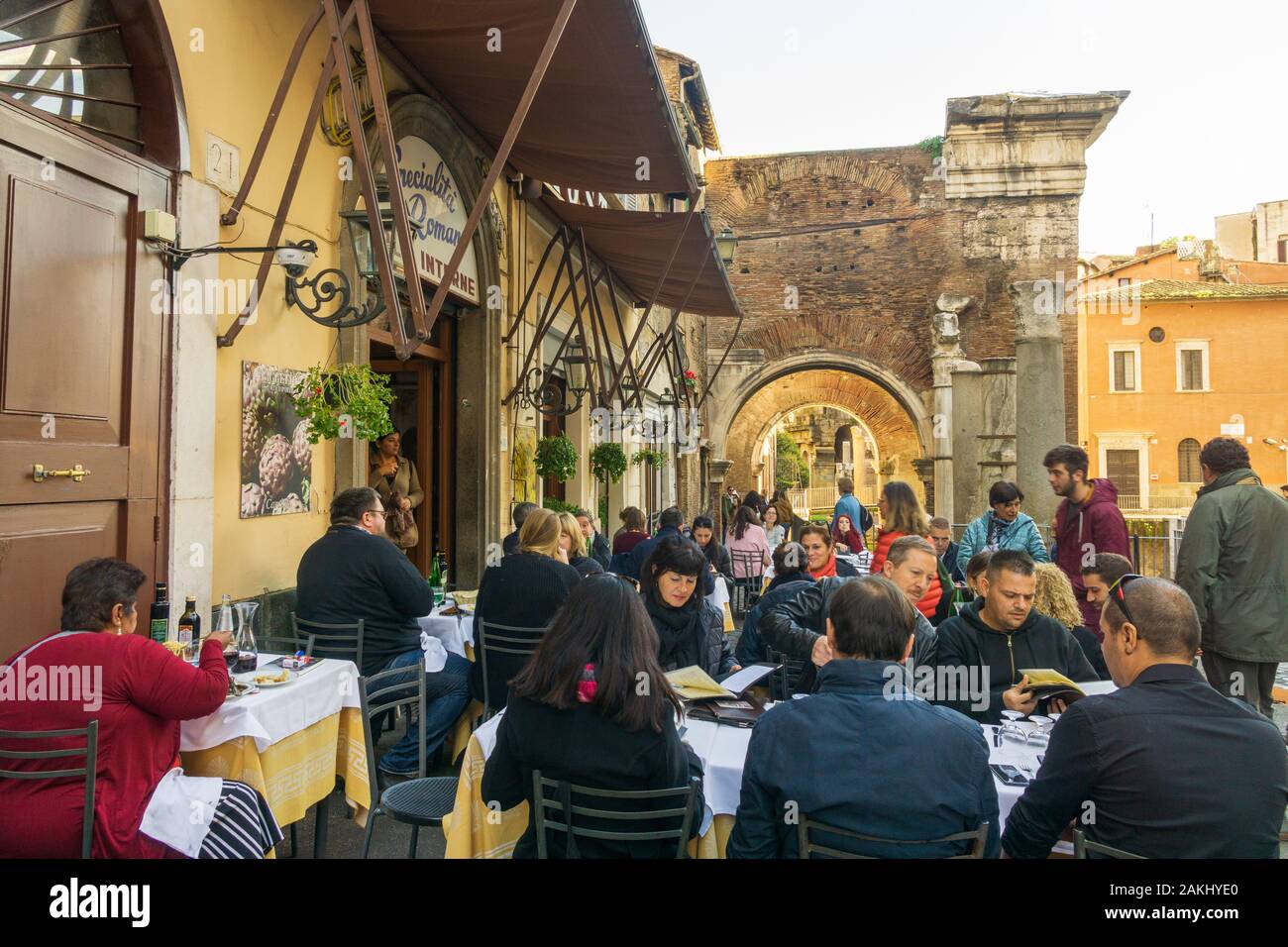 Die Menschen essen draußen in einer typischen Trattoria im Ghetto, dem jüdischen Viertel Roms, mit Portico von Octavia (Portico di Ottavia) im Hintergrund Stockfoto