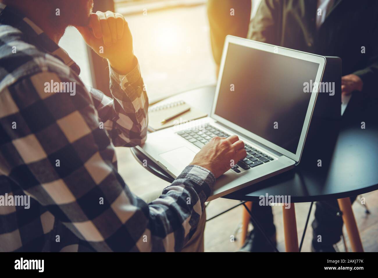 Business Mann arbeitet mit Laptop auf eine Tabelle in einem modernen Büro in der Nähe der Fenster Stockfoto