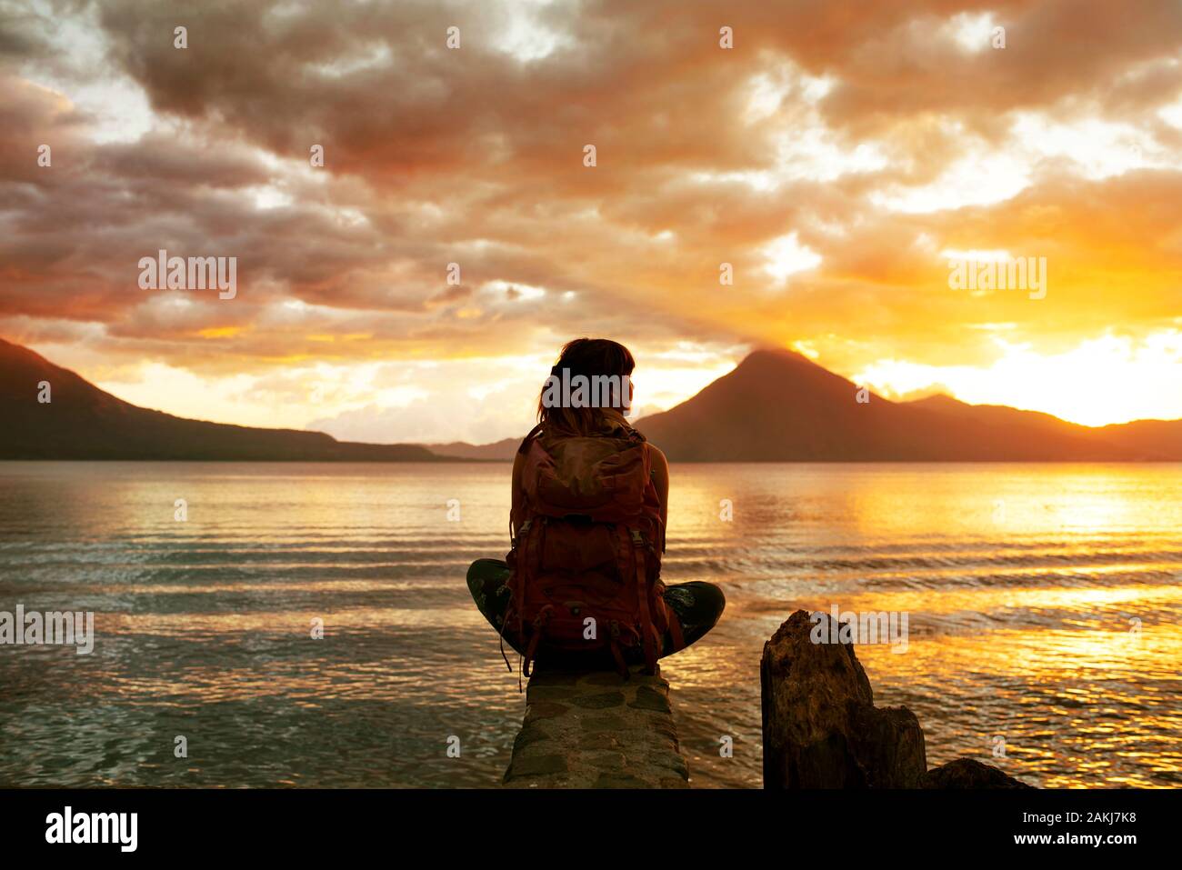 Rückblick auf die Backpacker von Frauen mit Blick auf den schönen Sonnenuntergang am Atitlan-See, Panajachel, Guatemala. Rucksackbilder für den Lebensstil von Reisen. Dezember 2018 Stockfoto