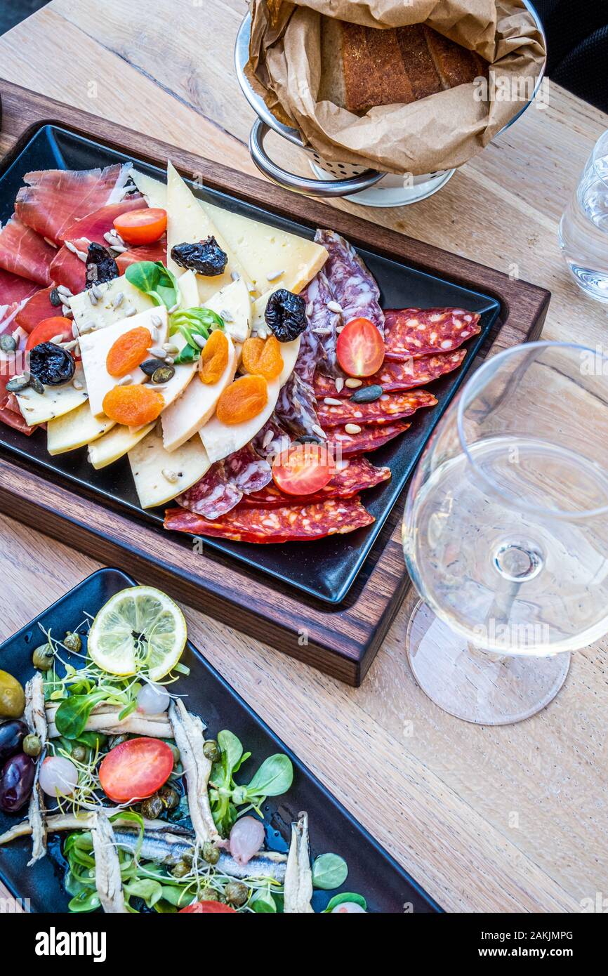 Köstliche, frische Antipasti auf Holzplatte, Salat mit Sardellen und Brot in Papier in dem schönen Restaurant in Italien, Europa Stockfoto