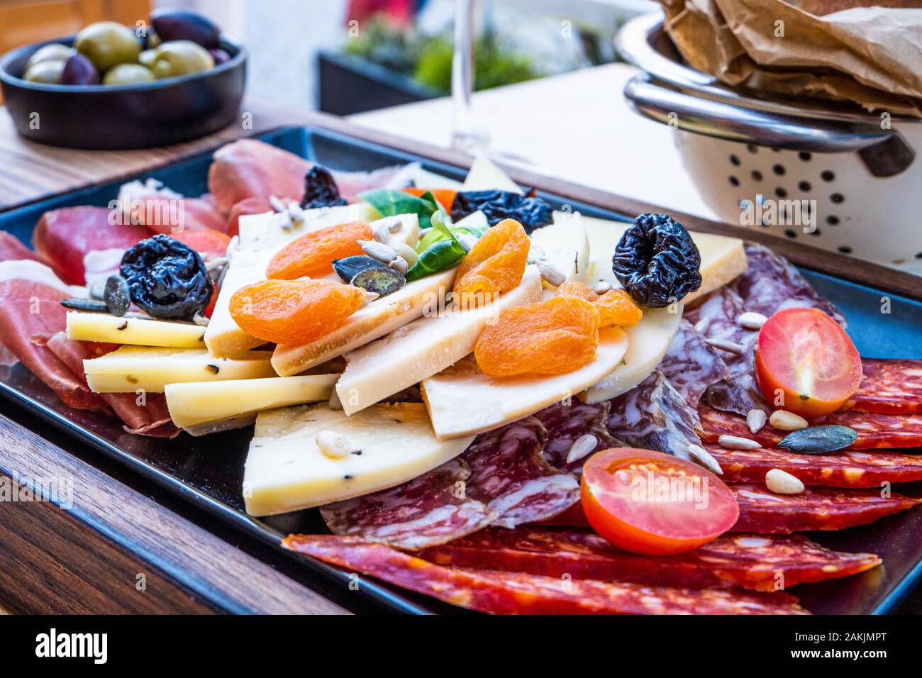 Köstliche, frische Antipasti auf Holzplatte, Salat mit Sardellen und Brot in Papier in dem schönen Restaurant in Italien, Europa Stockfoto